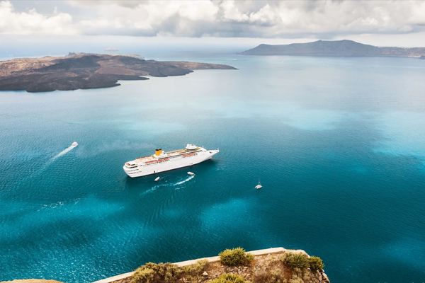 Crucero fondeado en el Egeo, visto desde un acantilado de Santorini